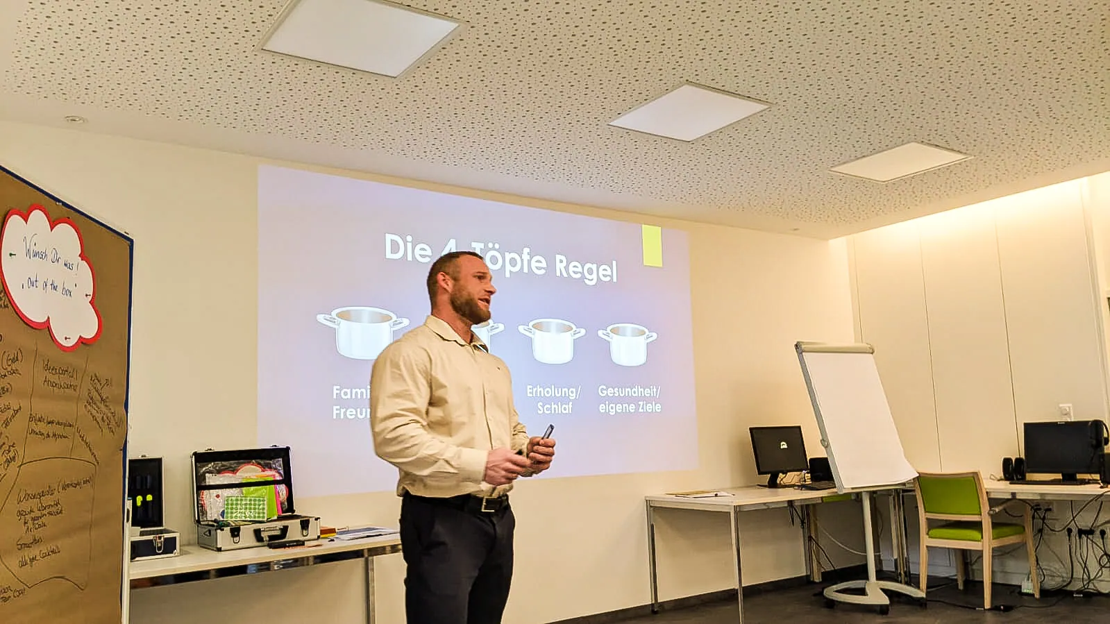 Dominik Dörfl explaining the Four Pots rule during a talk, in front of a slide showing four pots