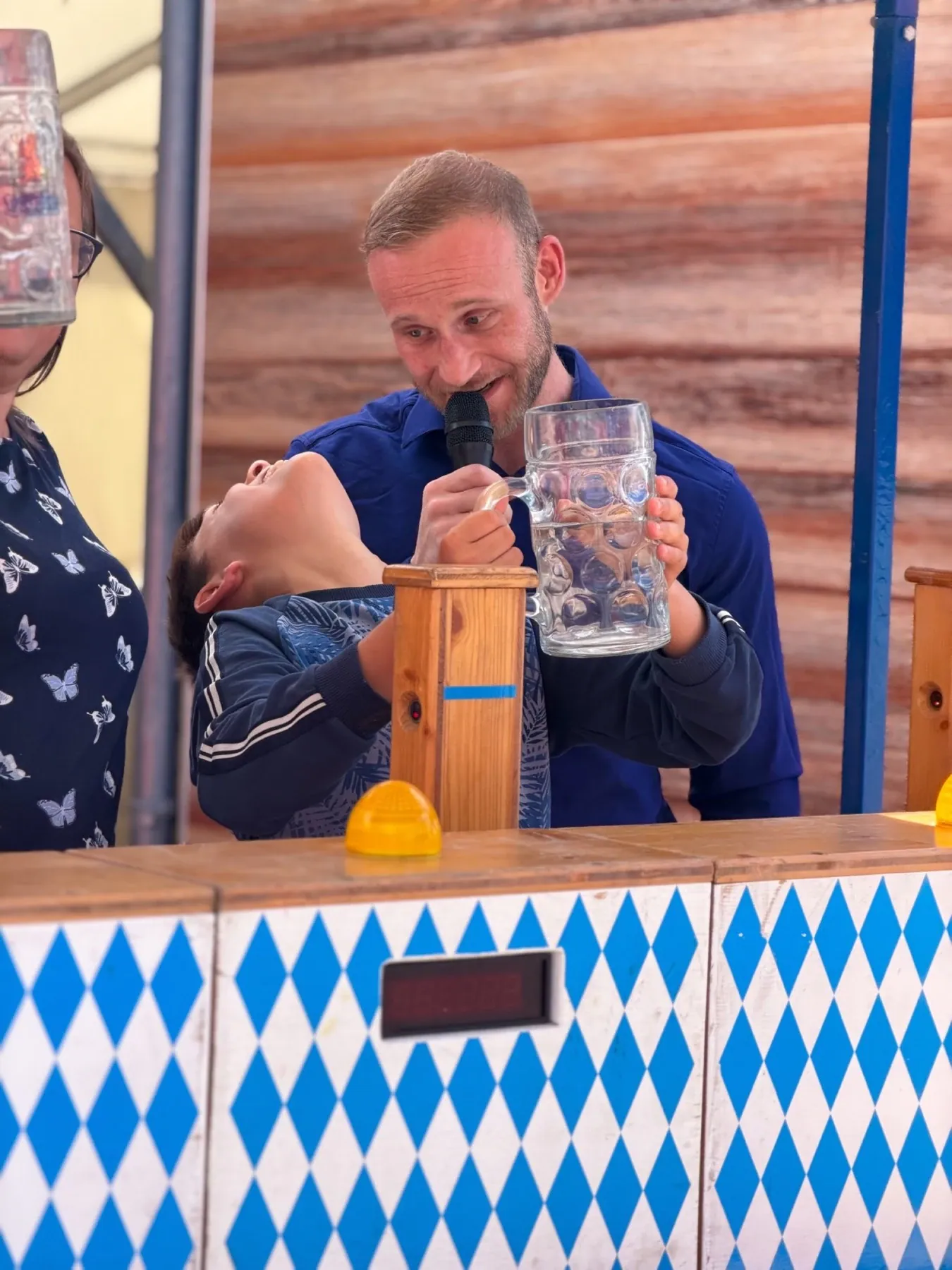 Dominik Dörfl moderiert ein Maßkrugstemmen mit einem Kind auf der Bühne